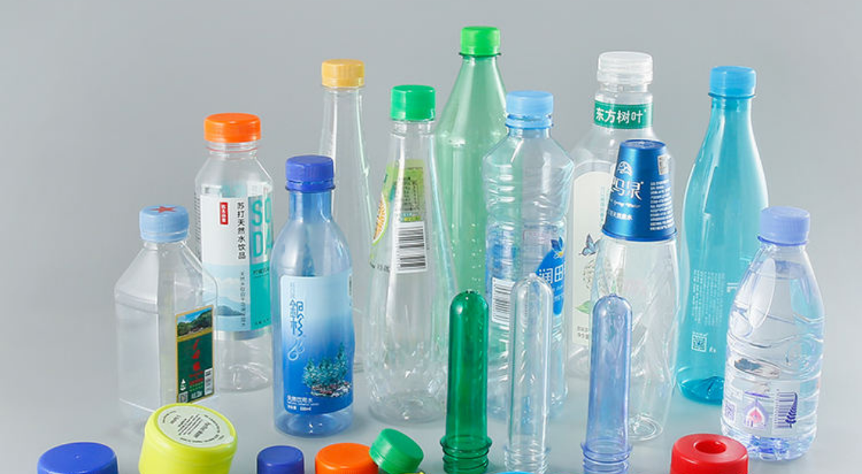 Various PET bottles and preforms in different colors and sizes, including labeled ones.