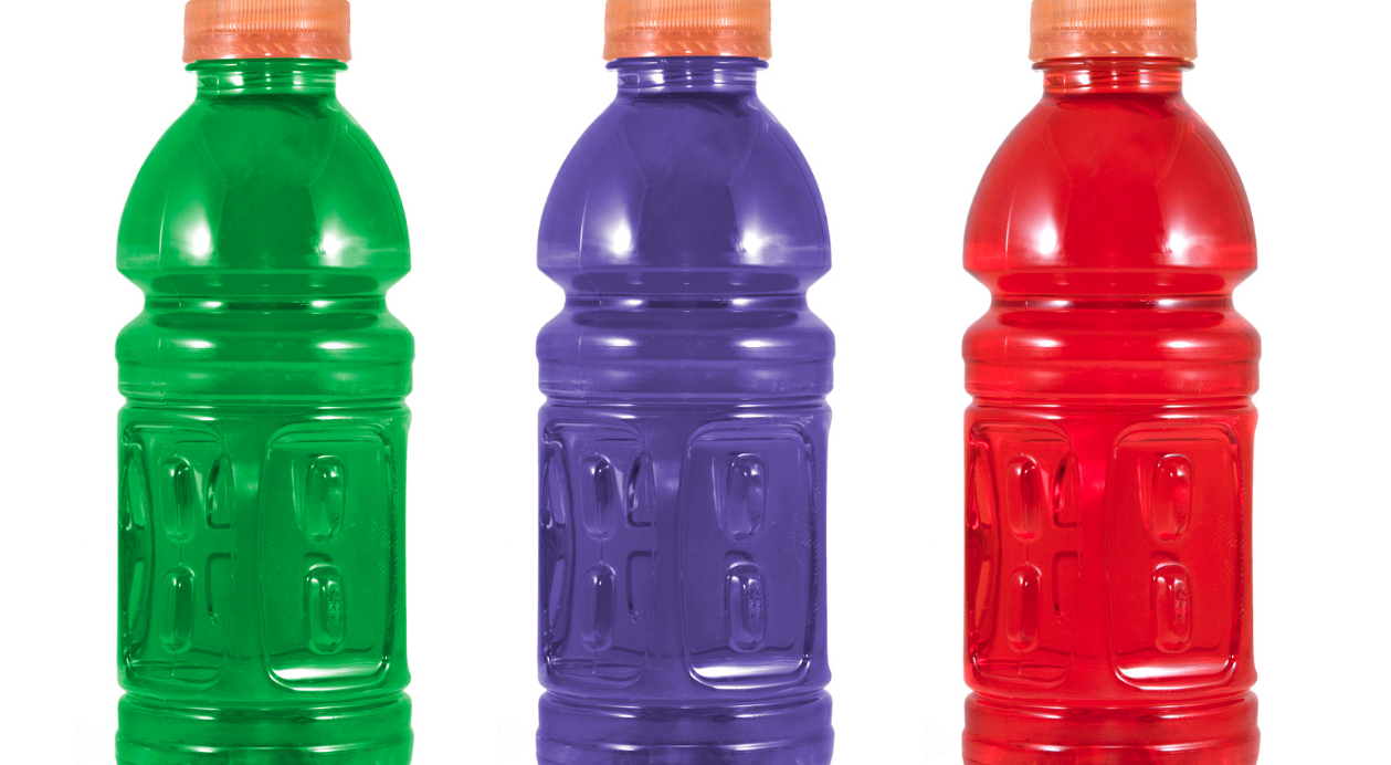 Three PET bottles in green, purple, and red, each with an orange cap.